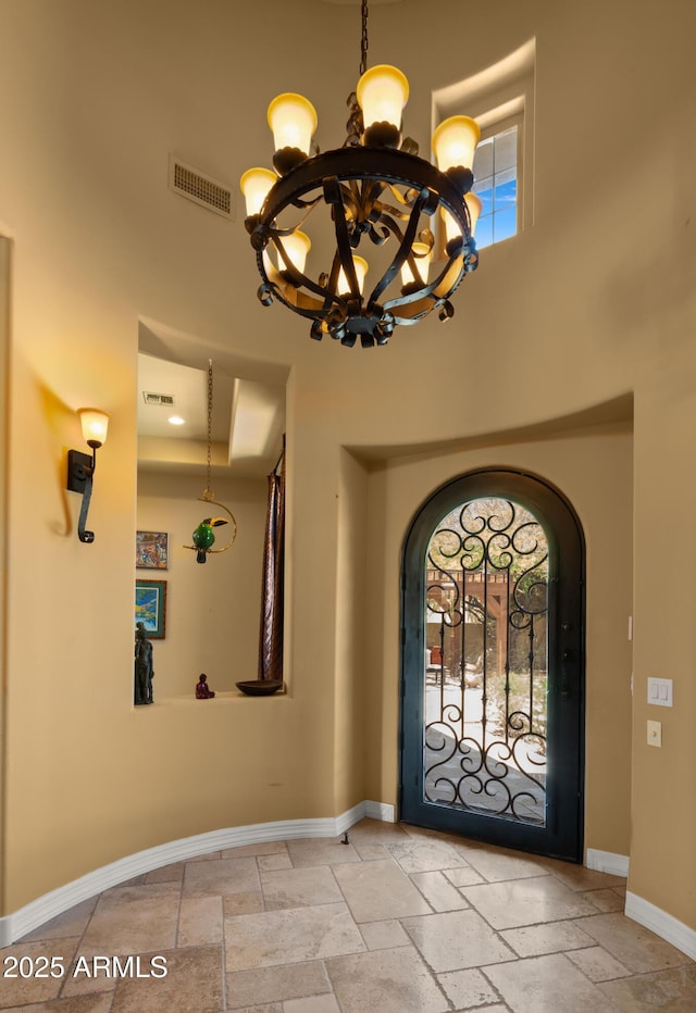 36813 N 109th Way, Scottsdale, AZ 85262 - entryway with a chandelier, stone tile flooring, a towering ceiling, and arched walkways