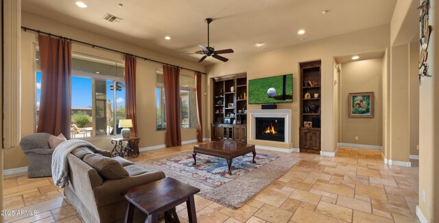 36813 N 109th Way, Scottsdale, AZ 85262 - living room with recessed lighting, ceiling fan, a glass covered fireplace, stone tile flooring, and built in features