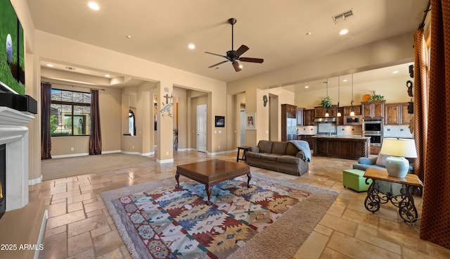 36813 N 109th Way, Scottsdale, AZ 85262 - living room with stone tile flooring, recessed lighting, a glass covered fireplace, and a ceiling fan