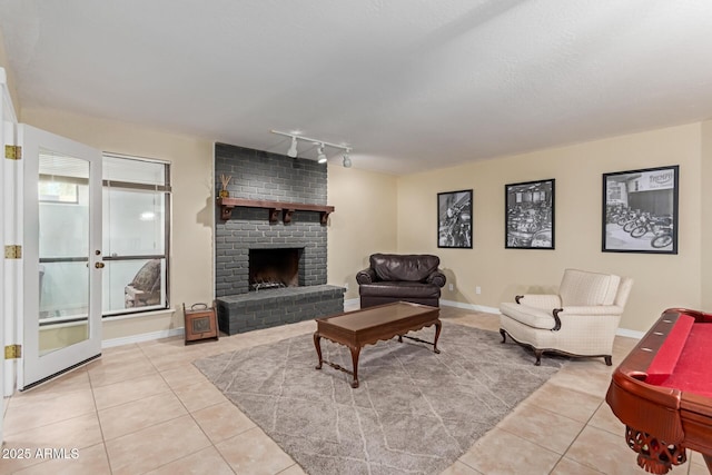12015 S Tuzigoot Dr, Phoenix, AZ 85044 - living room featuring light tile patterned floors, track lighting, a fireplace, and baseboards