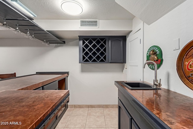 12015 S Tuzigoot Dr, Phoenix, AZ 85044 - laundry area with bar area, light tile patterned flooring, a textured ceiling, and baseboards