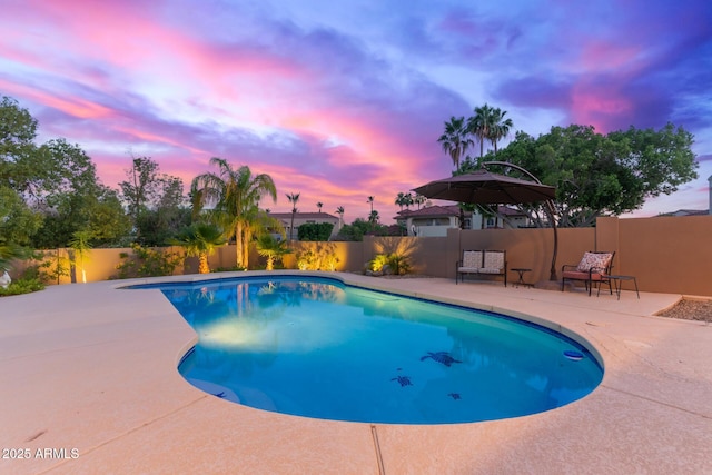 12015 S Tuzigoot Dr, Phoenix, AZ 85044 - pool at dusk with a patio and a fenced backyard
