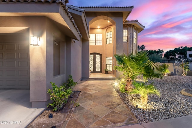 12015 S Tuzigoot Dr, Phoenix, AZ 85044 - exterior entry at dusk with stucco siding, french doors, and a tile roof