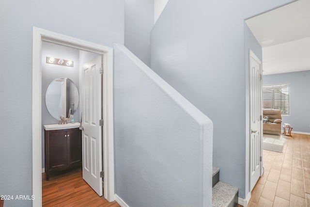 stairway with sink and wood-type flooring