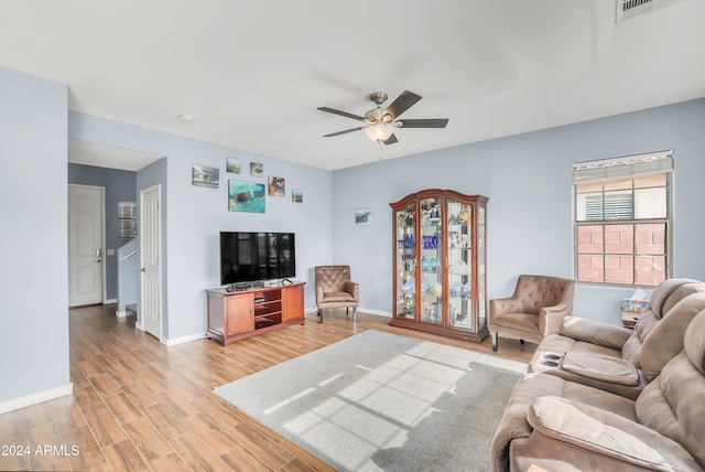 living room with ceiling fan and light hardwood / wood-style flooring