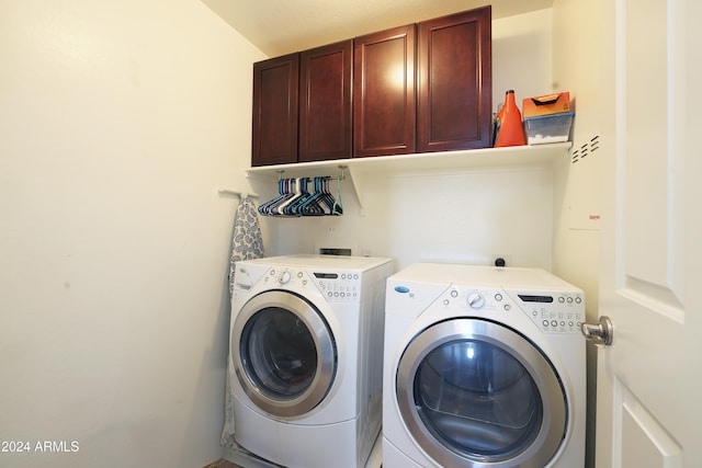 clothes washing area featuring cabinets and washing machine and dryer