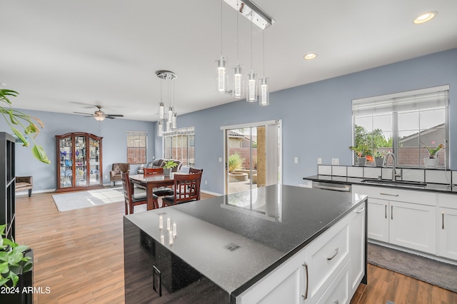 kitchen featuring pendant lighting, ceiling fan, a center island, and dark hardwood / wood-style flooring