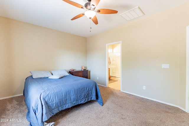 bedroom with ceiling fan, light carpet, and ensuite bath