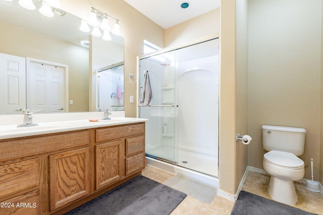 bathroom featuring tile patterned flooring, vanity, toilet, and an enclosed shower