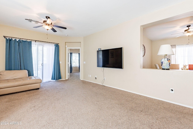 unfurnished living room featuring carpet flooring, ceiling fan, and a healthy amount of sunlight