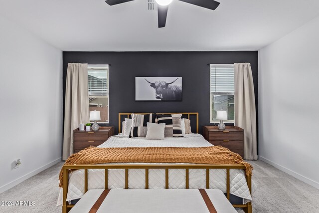 bedroom with multiple windows, light colored carpet, and ceiling fan