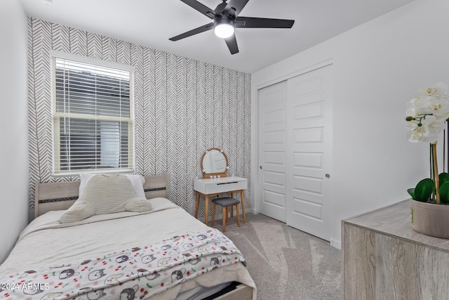 bedroom featuring light carpet, a closet, and ceiling fan