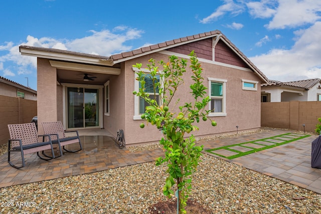 back of property with ceiling fan and a patio area