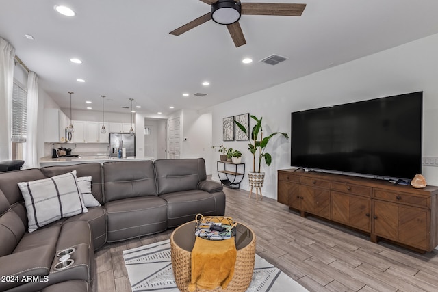 living room with light wood-type flooring and ceiling fan