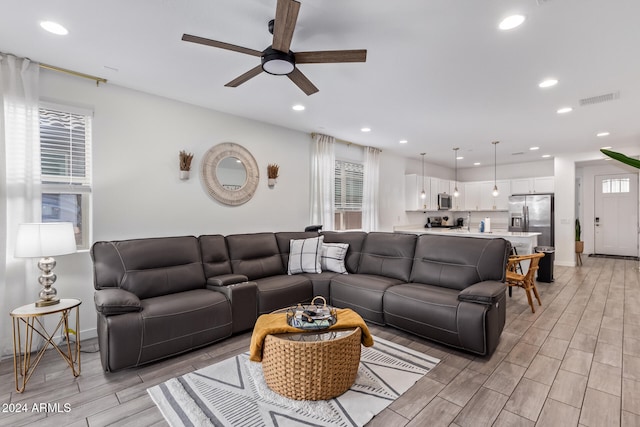 living room featuring light hardwood / wood-style flooring and ceiling fan