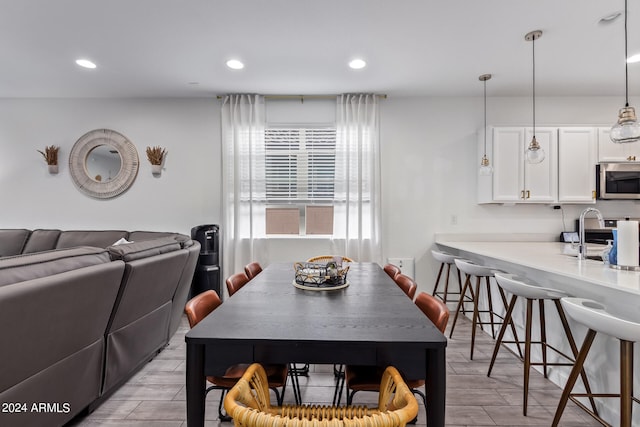 dining space featuring sink and light wood-type flooring