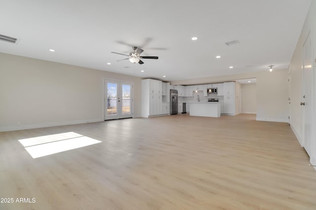 19118 W Fillmore St, Buckeye, AZ 85326 - unfurnished living room with light wood-style floors, baseboards, recessed lighting, a ceiling fan, and french doors