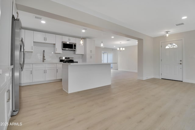 19118 W Fillmore St, Buckeye, AZ 85326 - kitchen featuring appliances with stainless steel finishes, light wood finished floors, baseboards, white cabinetry, and recessed lighting