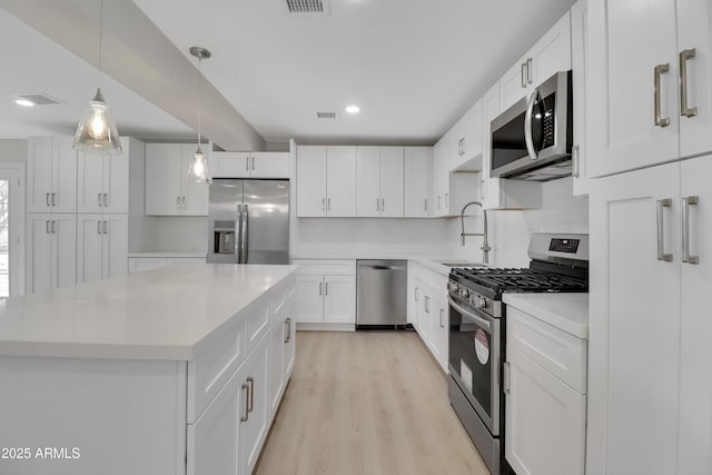 19118 W Fillmore St, Buckeye, AZ 85326 - kitchen with appliances with stainless steel finishes, a sink, light wood-type flooring, light countertops, and white cabinets