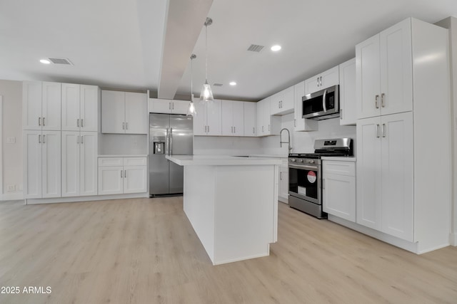 19118 W Fillmore St, Buckeye, AZ 85326 - kitchen featuring appliances with stainless steel finishes, light wood finished floors, light countertops, white cabinetry, and recessed lighting