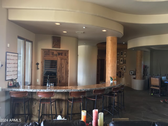 kitchen featuring stone counters, kitchen peninsula, and a breakfast bar