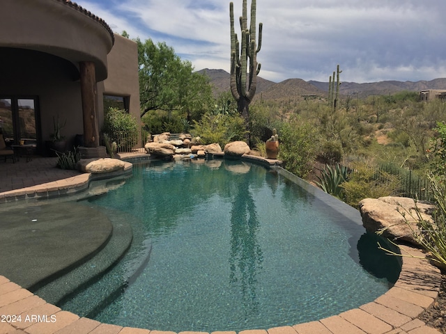 view of swimming pool with a patio area and a mountain view