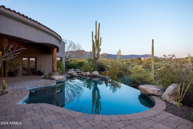 view of pool with a mountain view and a patio