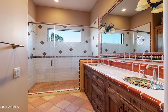 bathroom with tasteful backsplash, a shower with door, tile floors, and double sink vanity