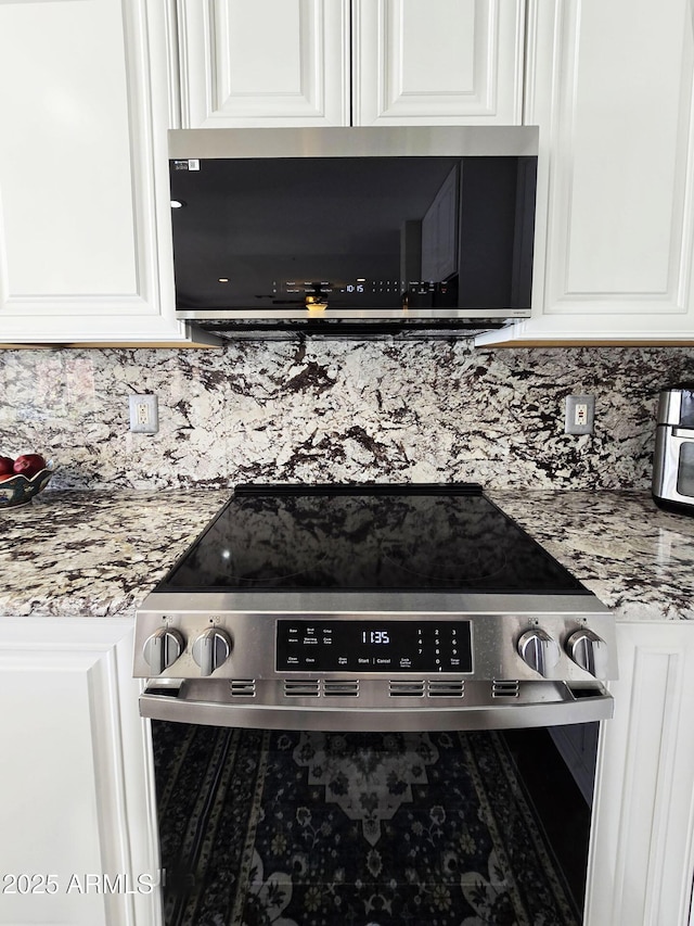 details with stainless steel appliances, white cabinetry, light stone counters, and decorative backsplash