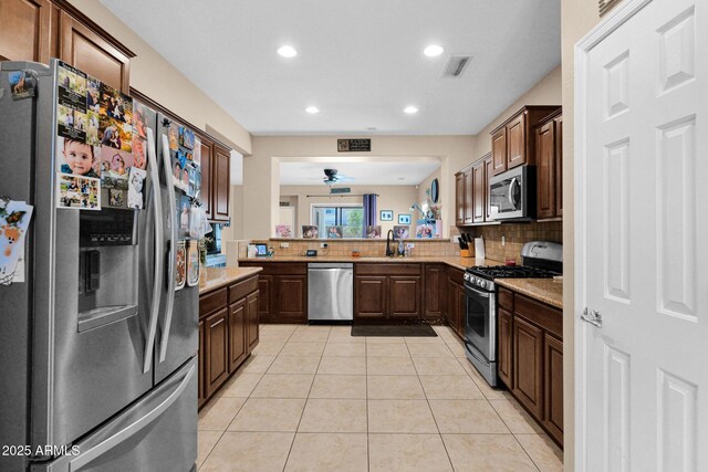 kitchen featuring light countertops, appliances with stainless steel finishes, tasteful backsplash, and visible vents