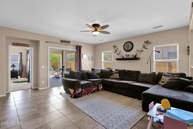 living area featuring tile patterned flooring, ceiling fan, baseboards, and visible vents