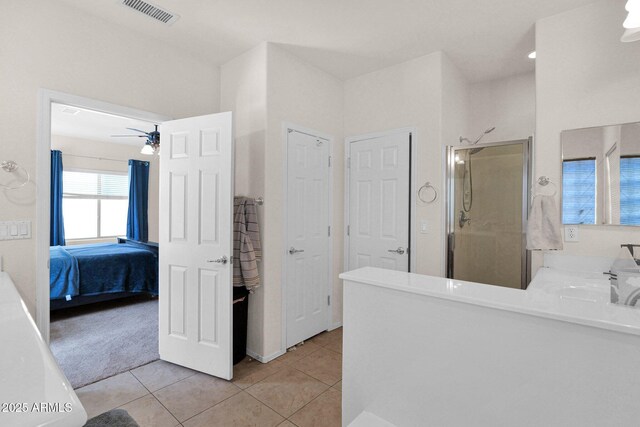 ensuite bathroom with connected bathroom, ceiling fan, tile patterned flooring, visible vents, and a stall shower