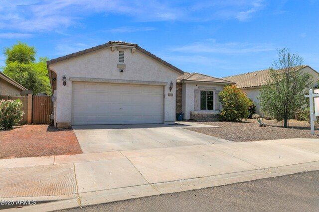 single story home featuring driveway, a gate, fence, an attached garage, and stucco siding