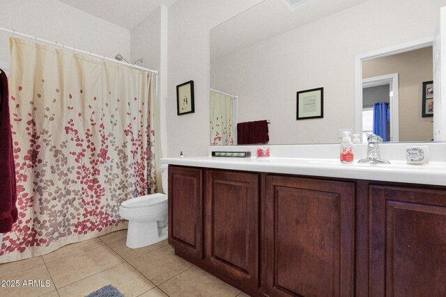 bathroom with toilet, curtained shower, tile patterned flooring, and vanity