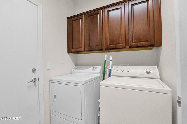 clothes washing area with washer and clothes dryer and cabinet space