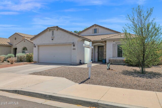 view of front of house with concrete driveway, an attached garage, a tile roof, and stucco siding