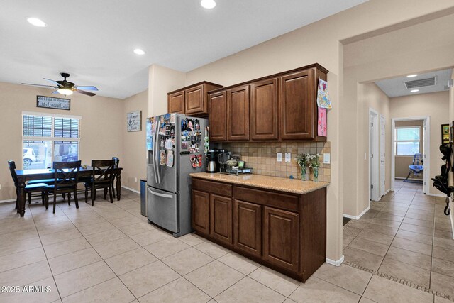 kitchen with visible vents, stainless steel fridge with ice dispenser, light tile patterned flooring, baseboards, and tasteful backsplash