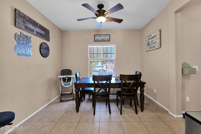 dining space featuring baseboards, ceiling fan, and light tile patterned flooring