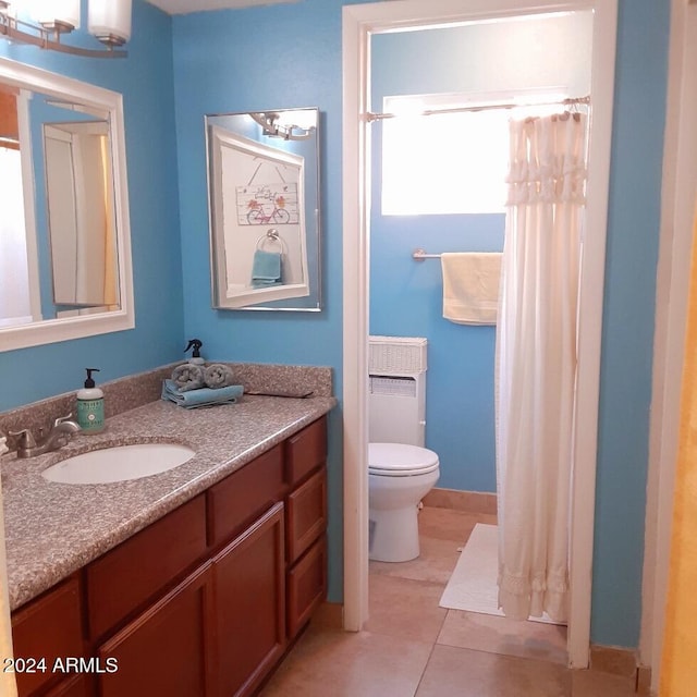 bathroom with tile patterned flooring, vanity, and toilet