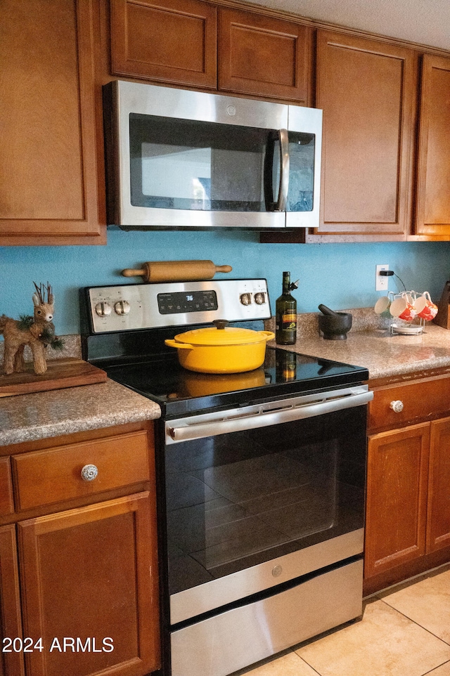 kitchen with light tile patterned flooring and appliances with stainless steel finishes