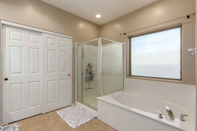 full bath featuring a stall shower, a garden tub, and tile patterned floors