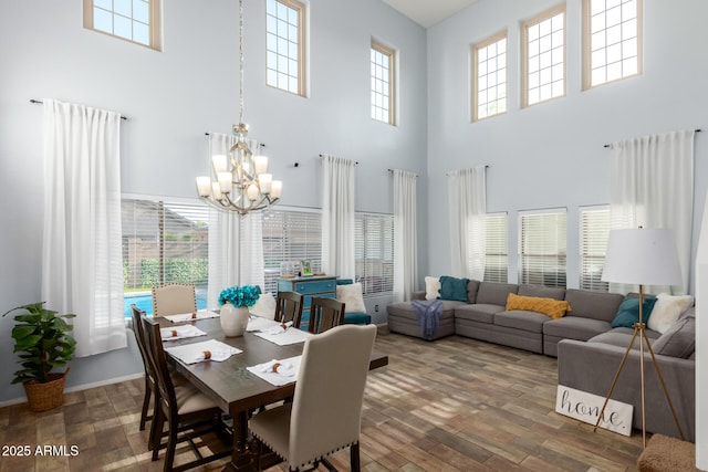 dining room with a wealth of natural light, a notable chandelier, and wood finished floors