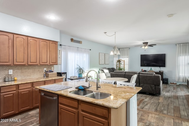 kitchen with tasteful backsplash, a sink, stainless steel dishwasher, and wood finished floors