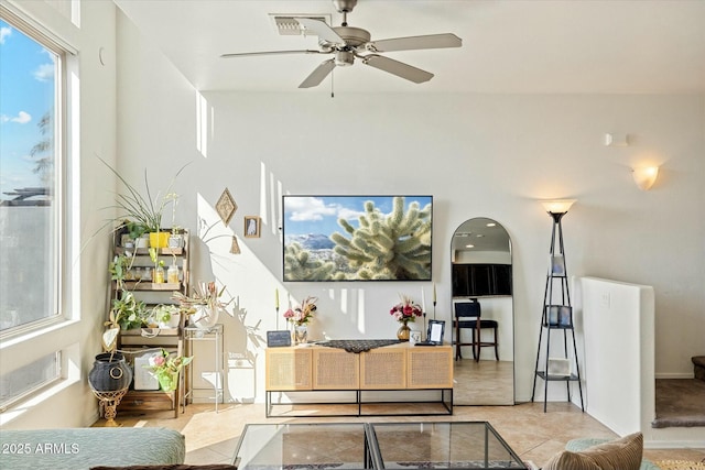 living room with tile patterned floors, visible vents, and ceiling fan