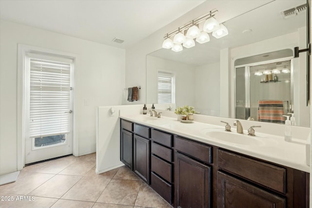 bathroom with a sink, visible vents, double vanity, and tile patterned flooring