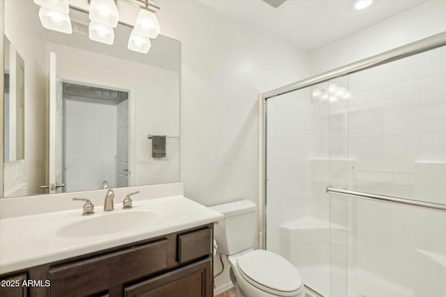 bathroom with a stall shower, toilet, and vanity