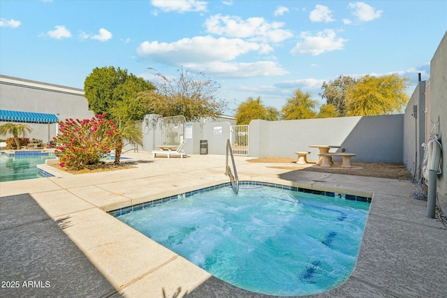 community pool featuring a patio, fence, and a gate