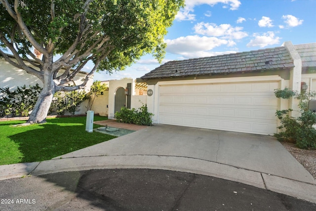 view of front of property featuring a garage and a front lawn