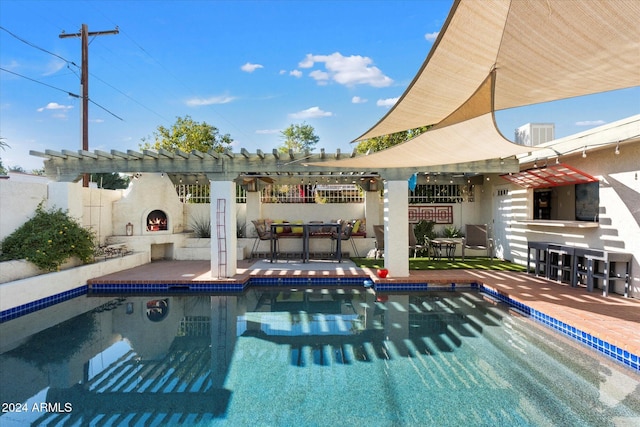 view of swimming pool with a patio area and exterior fireplace