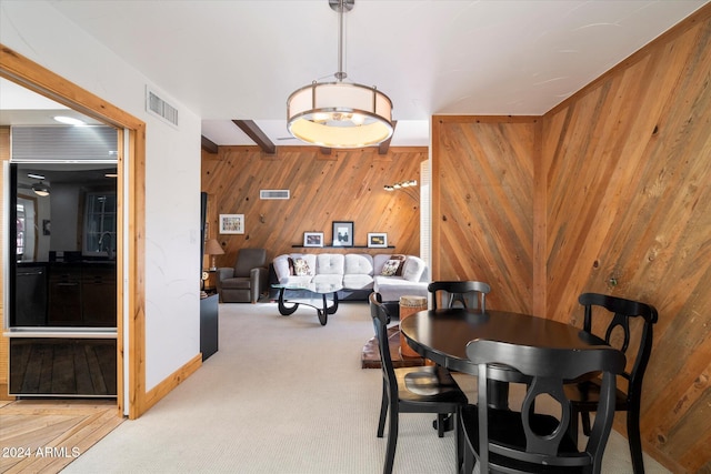 dining room with wood walls and light colored carpet